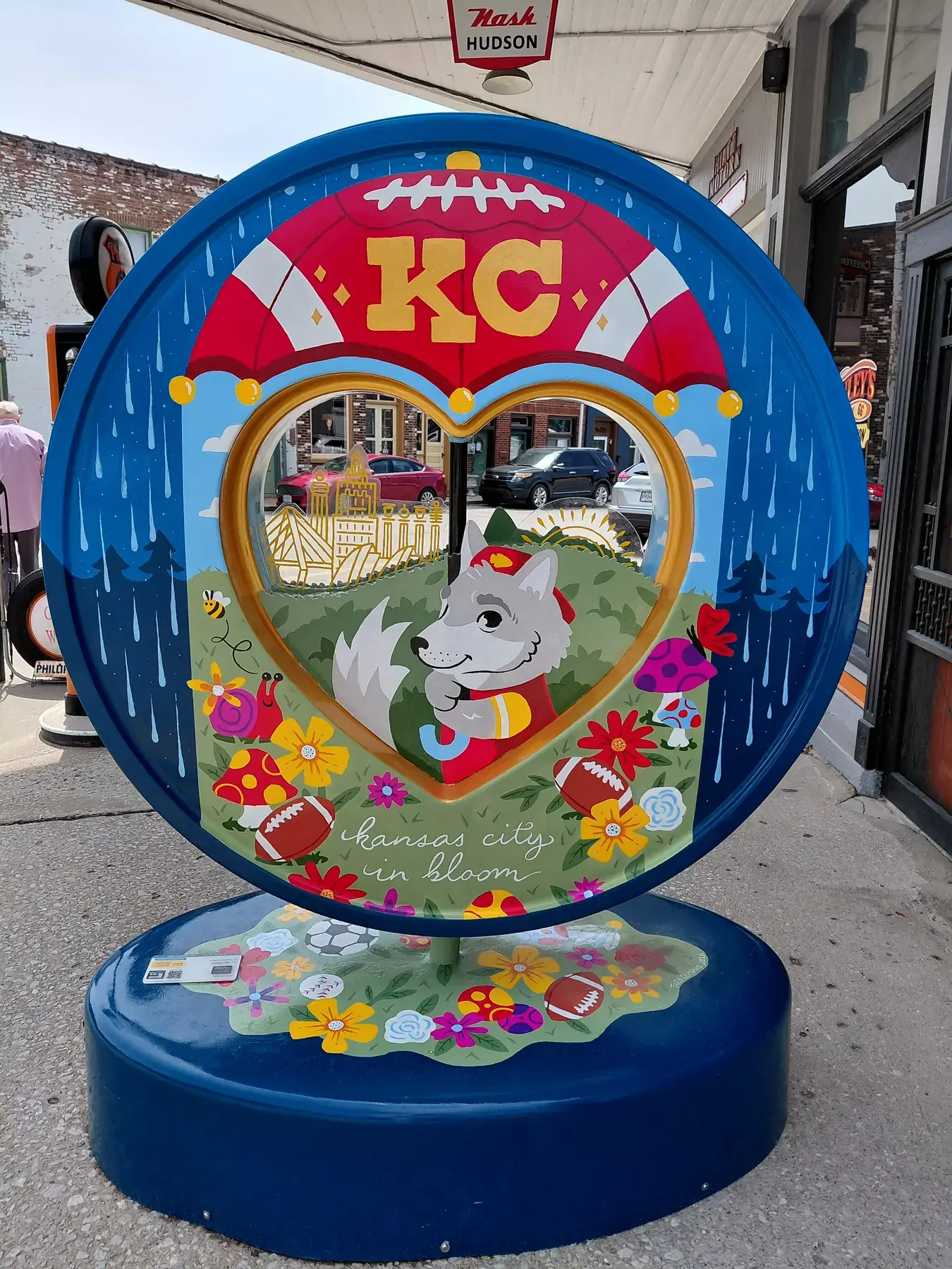 Colorful painted heart sculpture on a small-town sidewalk